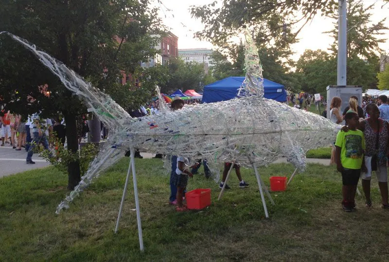 The shark on its stands at dusk, children looking up at it