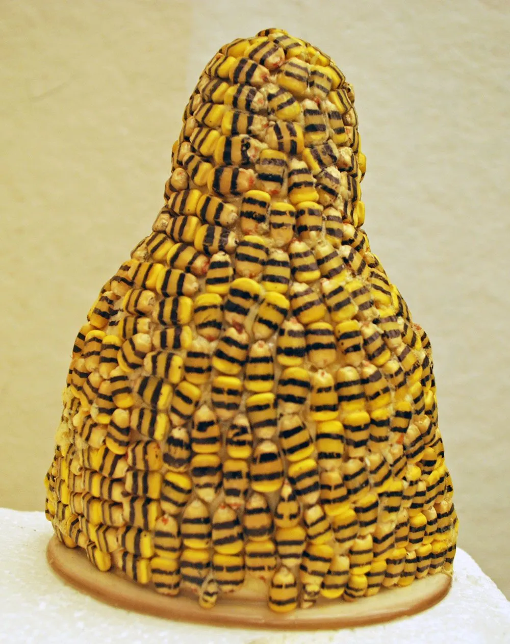 The back of the figure, entirely covered in rows of yellow and black corn kernels