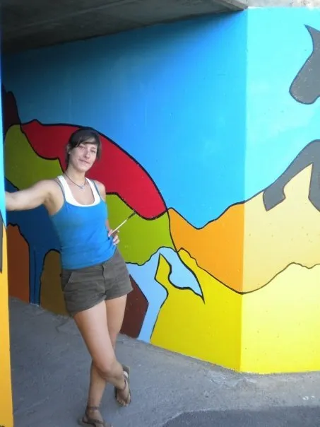 Standing against the finished mural where it wraps the corner of the underpass
