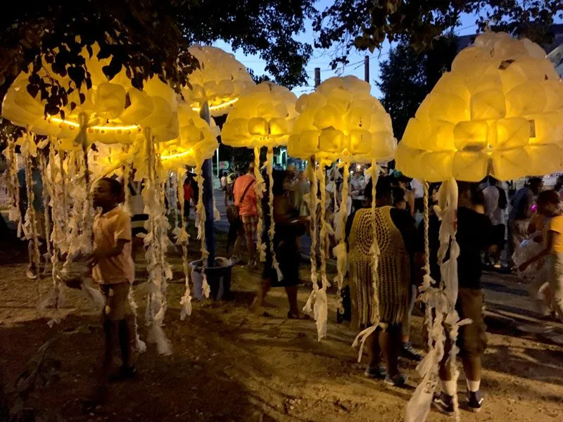 The group lit from within at dusk, glowing yellow above the crowd