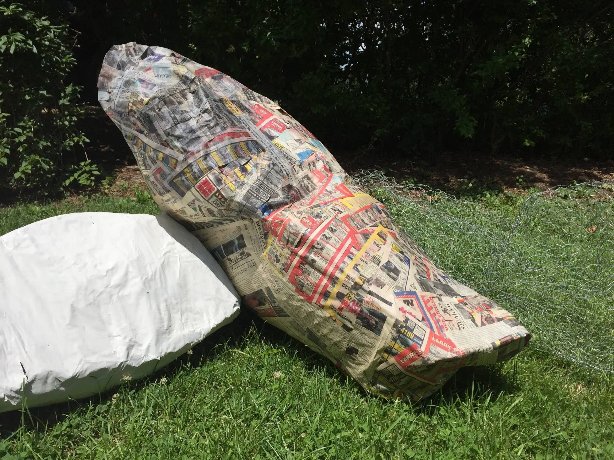 A boulder under construction, papier-mâché over a chicken wire frame