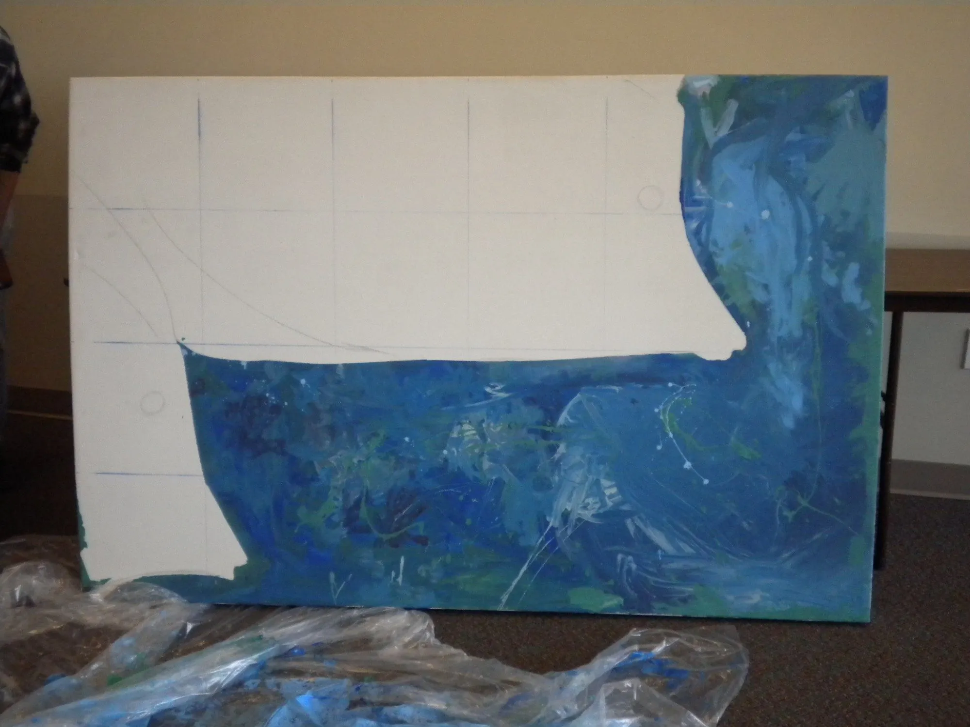 A panel part-painted, deep blue and green water filling in around the masked white shape of a fish