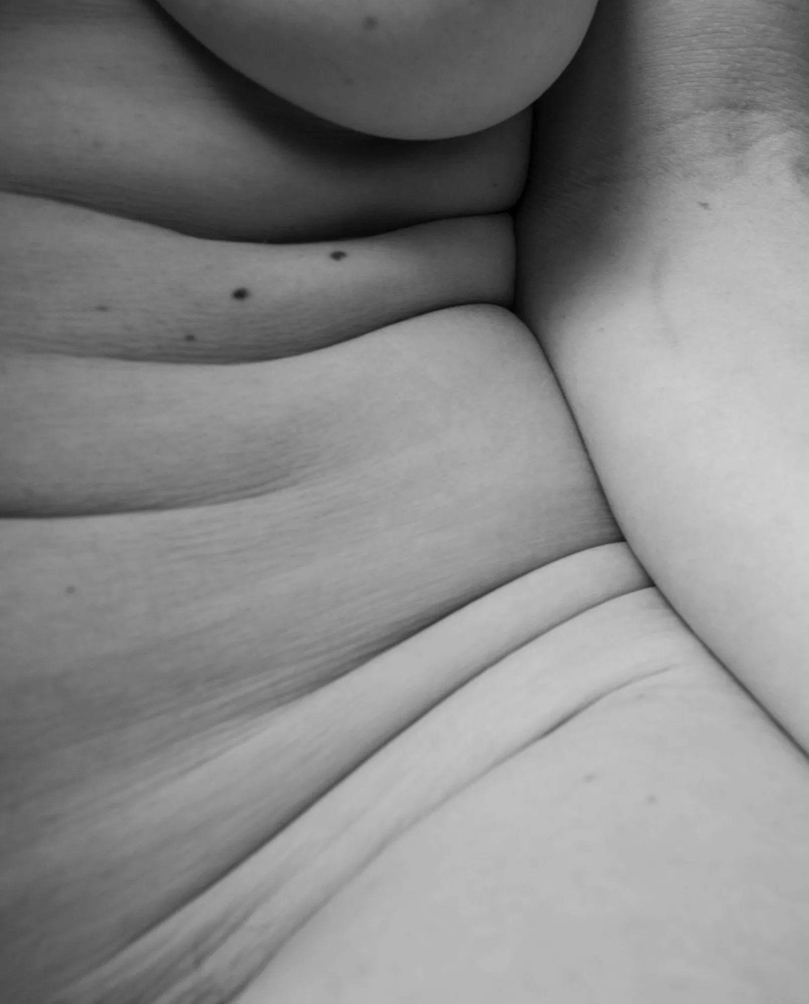The underside of a breast resting above a stack of soft folds