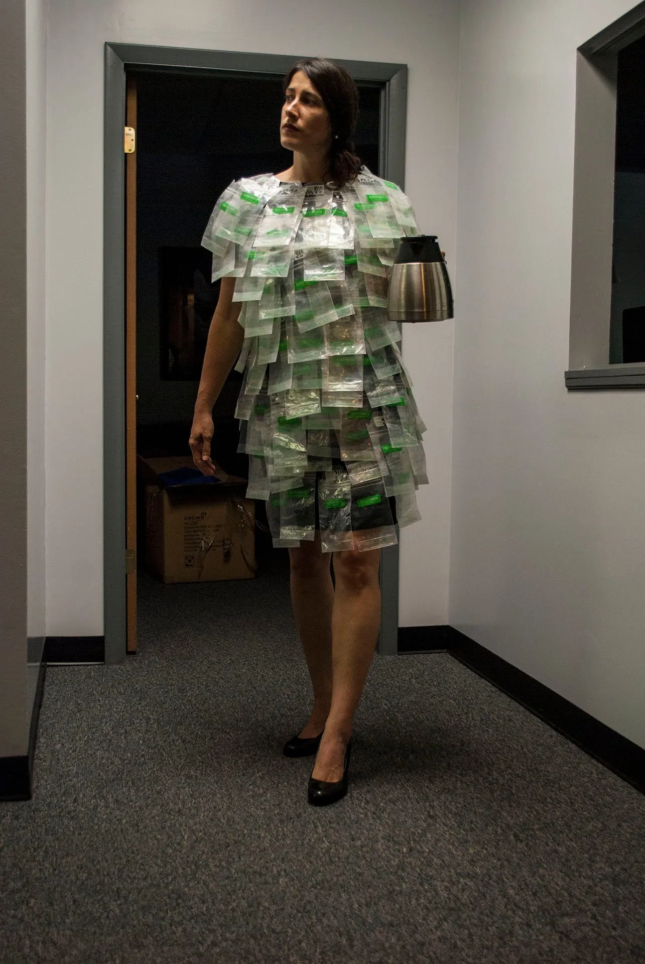 Standing in an office doorway at the end of the day, holding a coffee carafe