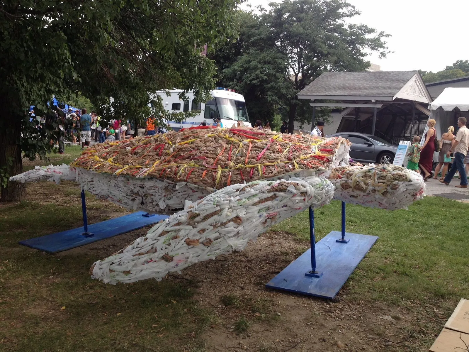 The finished turtle raised on steel stands on the grass, festival tents behind it