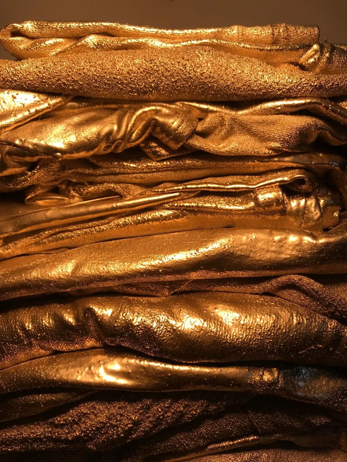 Detail of the stack, the gilded folds and hems layered one on another