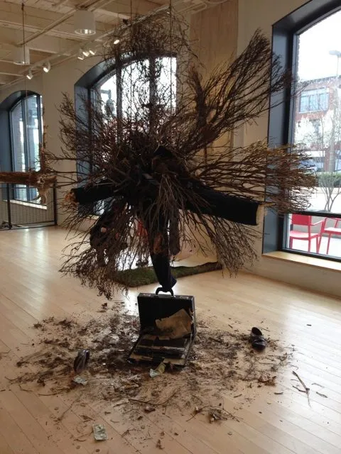The branch burst seen closer, the suitcase open at its base amid the scattered debris