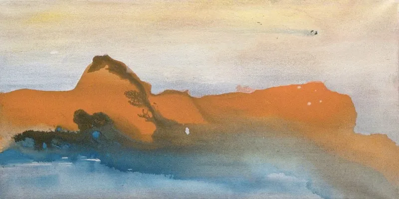 A mass of burnt orange settled over blue water, the sky above it soft and pale