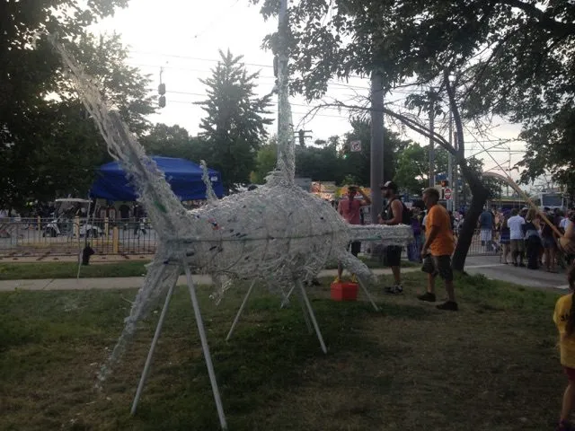 The shark at dusk from the front, festival tents behind it