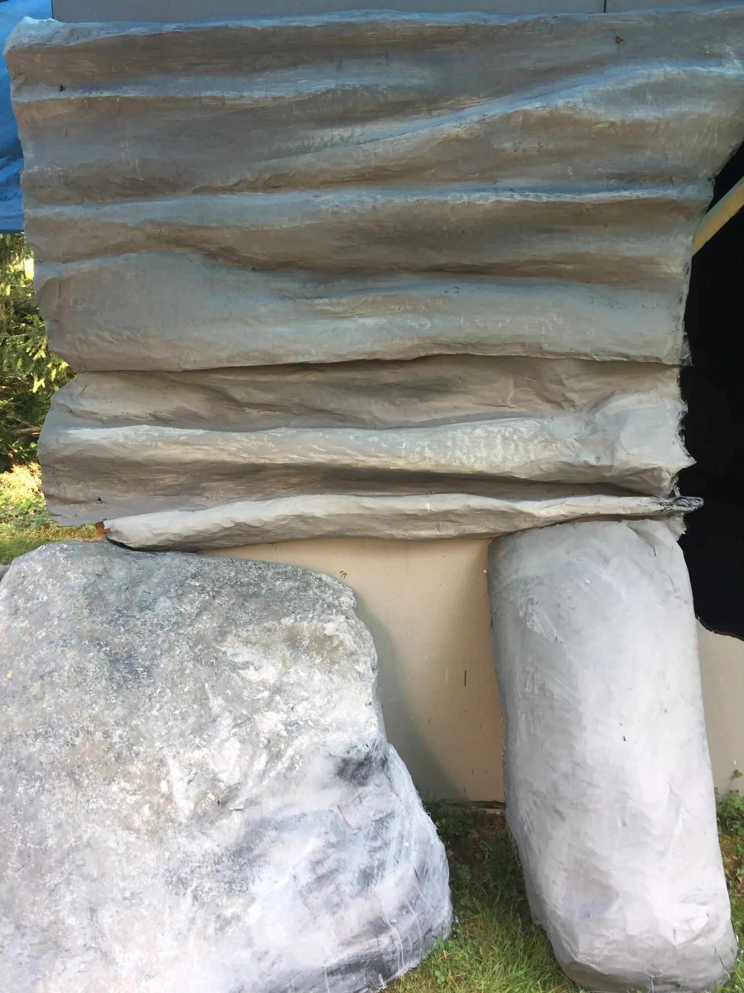 Close up of the finished rock face, its layers painted in greys and blues