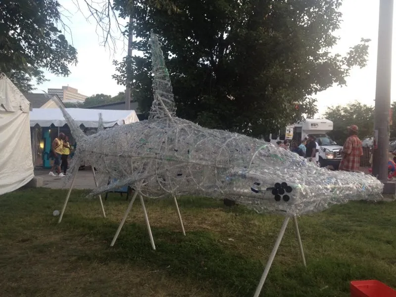 The whole shark at dusk from the side, marquee tents behind it