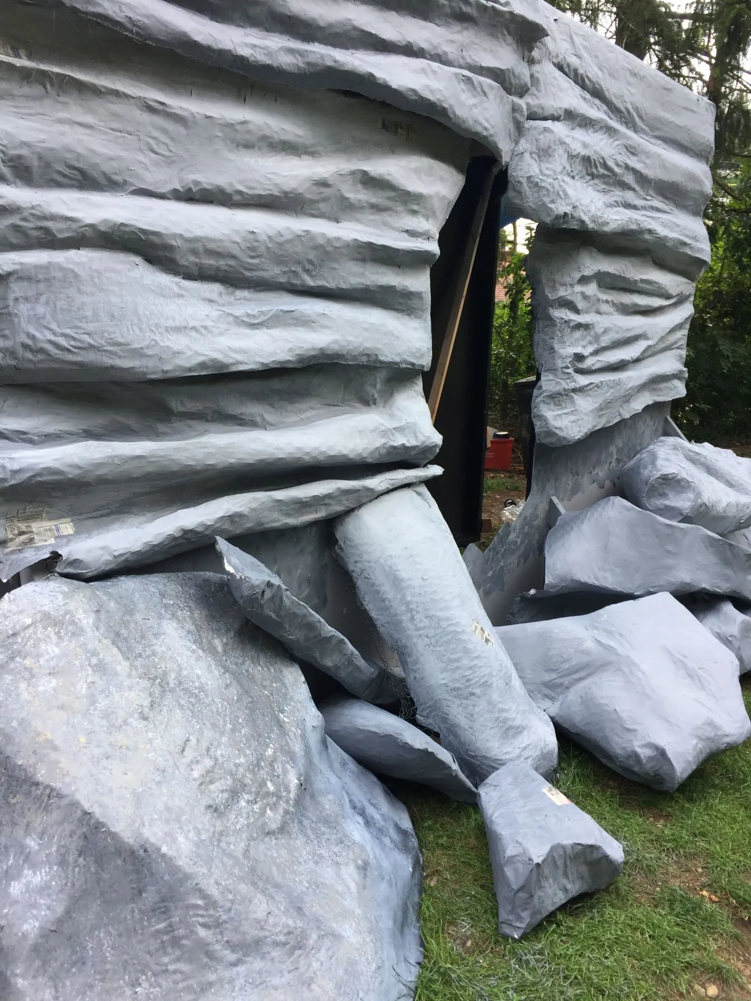 The painted rock face and boulders seen from the side