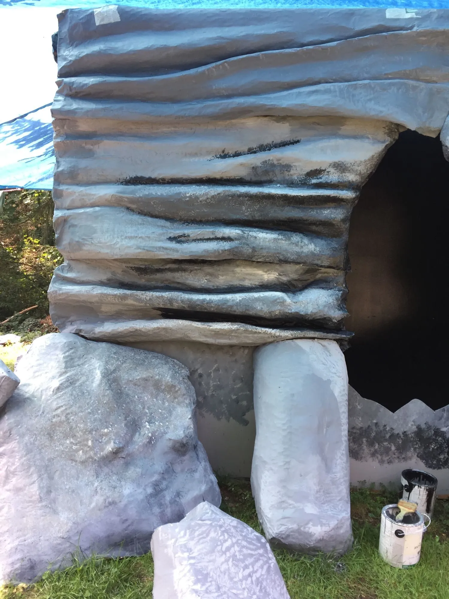 The faux painted wall around the cave opening, paint cans still at its foot